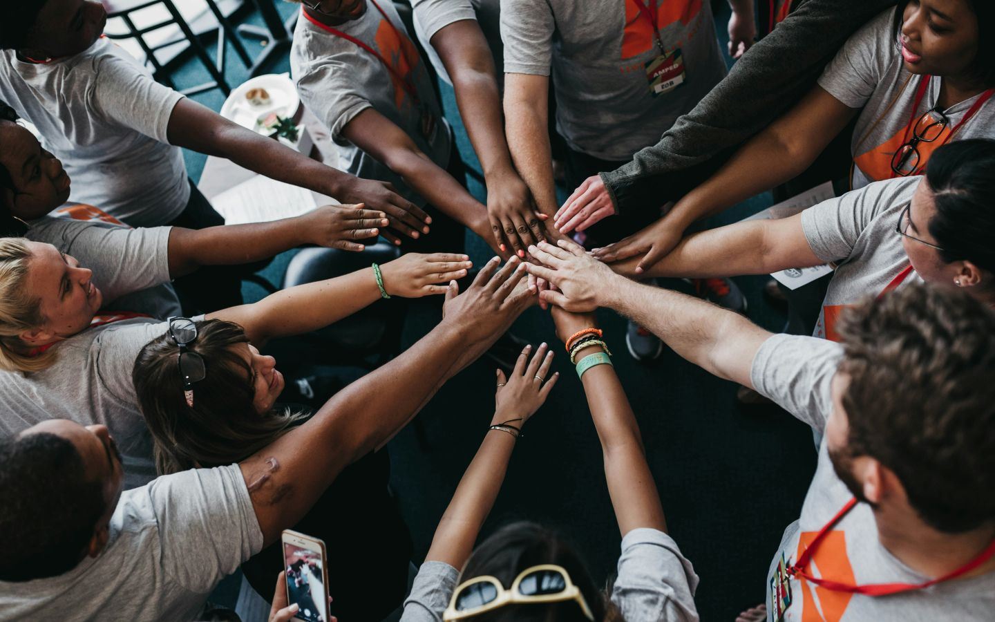 Colleagues stacking their hands together in a circle before a team activity